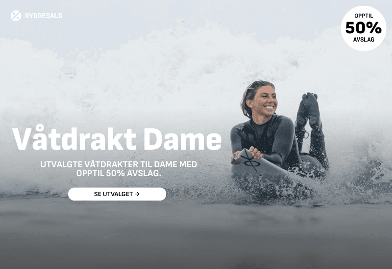 Lykkelig dame med stort smil. På vei inn etter en god surfeøkt.