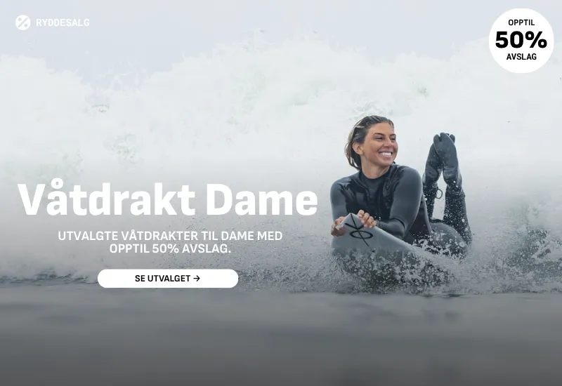 Lykkelig dame med stort smil. På vei inn etter en god surfeøkt.